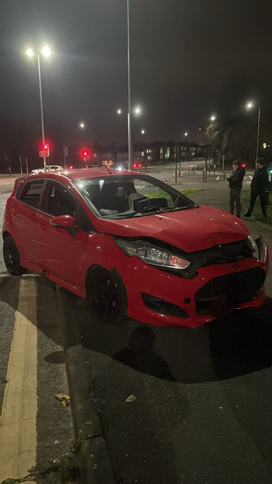 Accident damaged vehicle on the roadside.