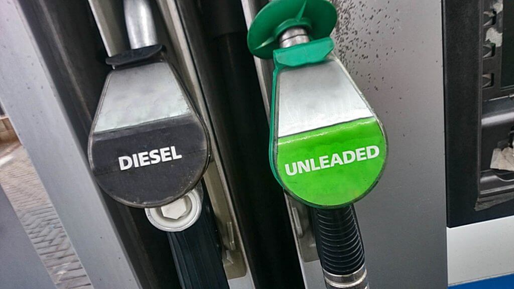 Diesel and unleaded fuel pump nozzles side by side at a petrol station
