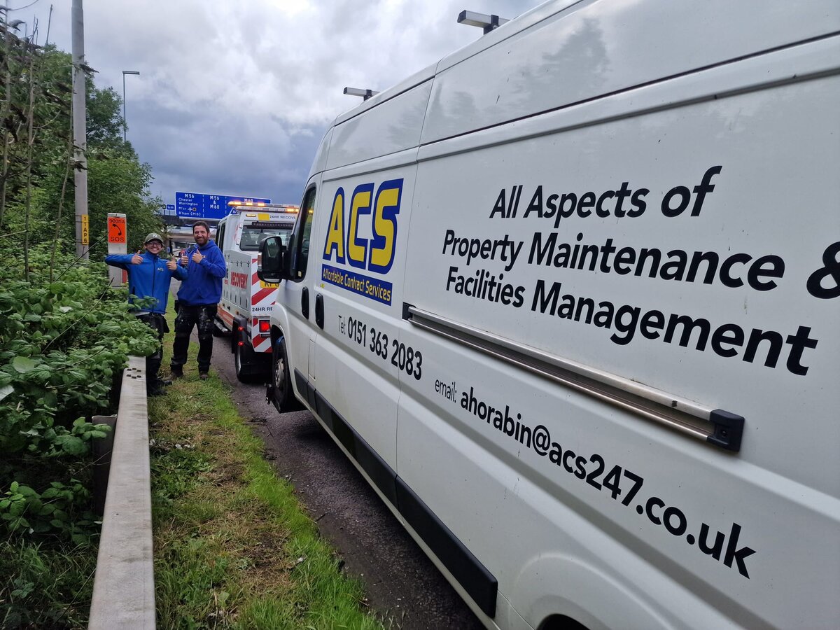 ACS Property Maintenance white panel van pulled in by the guardrail, ready to be loaded onto Breakdown Man's recovery truck.