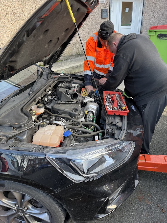 A Breakdown Man technician performing an under-bonnet roadside repair.