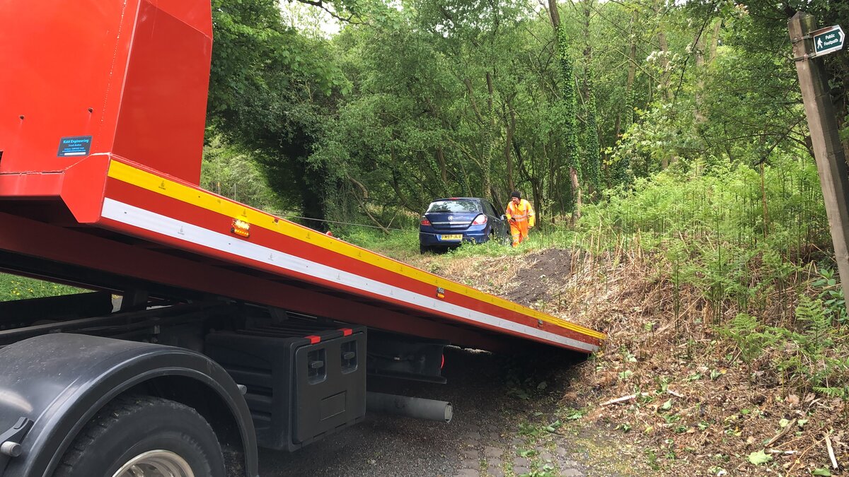 Breakdown Man recovery truck loading a vehicle on a rural lane, the type of touring road caravans travel