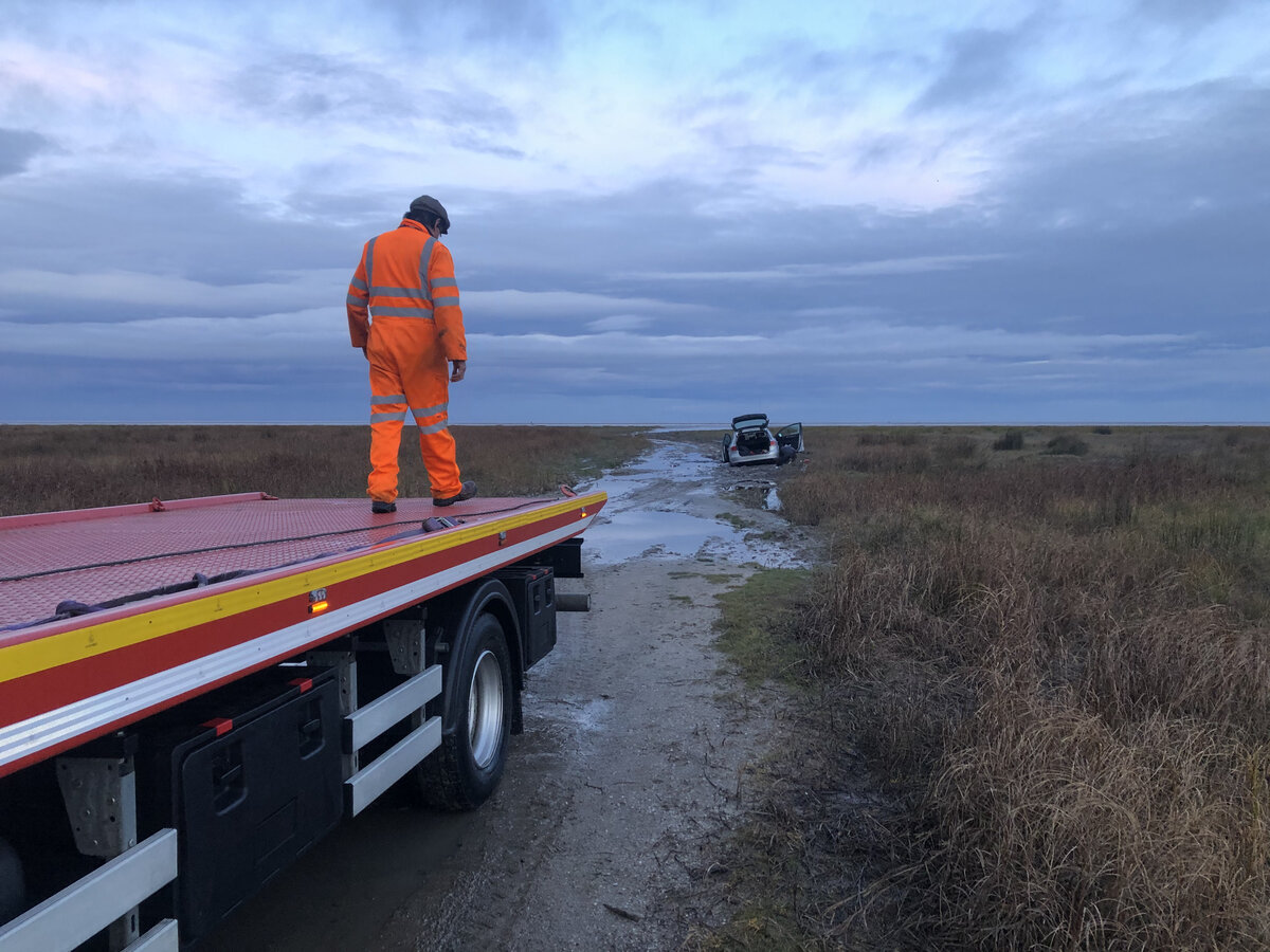 Breakdown Man recovery truck recovering a stranded vehicle at first light