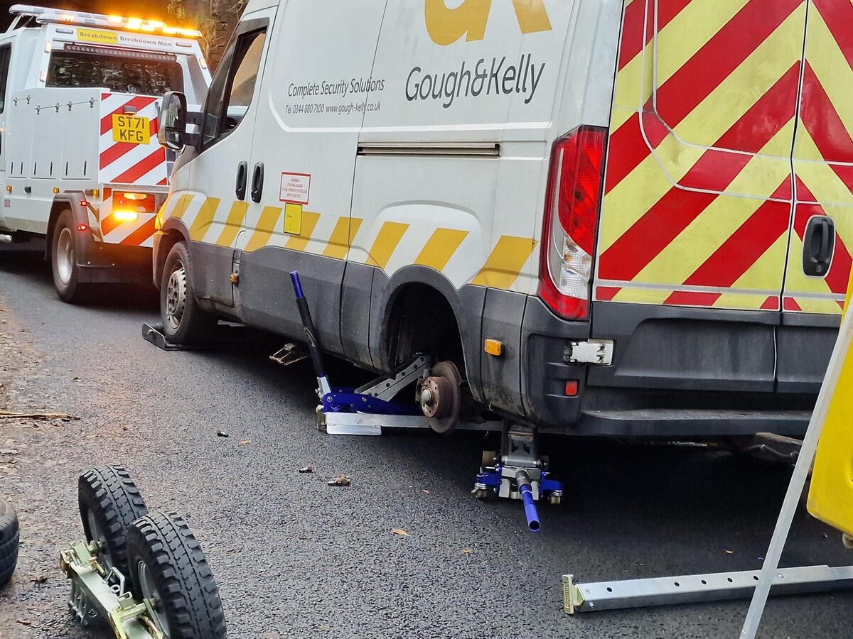 Breakdown Man recovery truck ST71 KFG with a Gough & Kelly Iveco van having its rear wheel removed kerbside.
