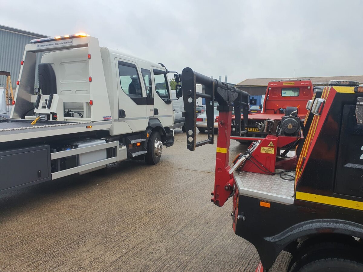 Two Breakdown Man recovery trucks lined up in the yard, ready for roadside breakdown jobs near Leigh.