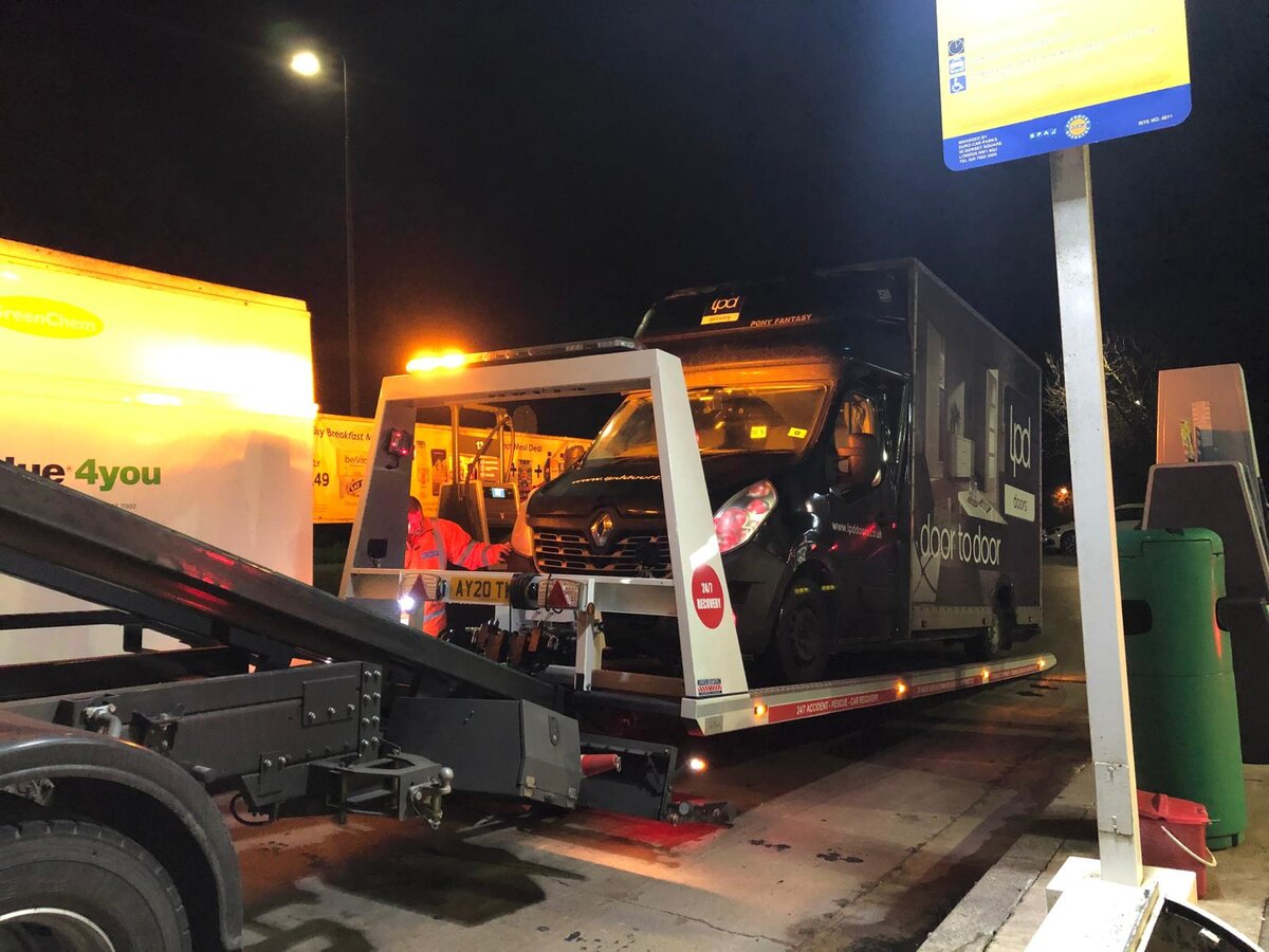 Breakdown Man Renault flatbed loaded with a courier van at a North West petrol station after a wrong fuel job