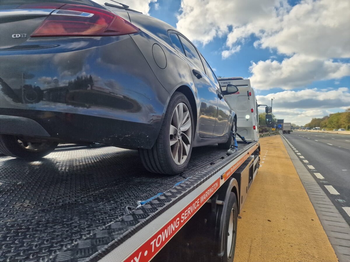 A Vauxhall Insignia loaded on Simon's flatbed on the M57 — typical Liverpool-area tow.