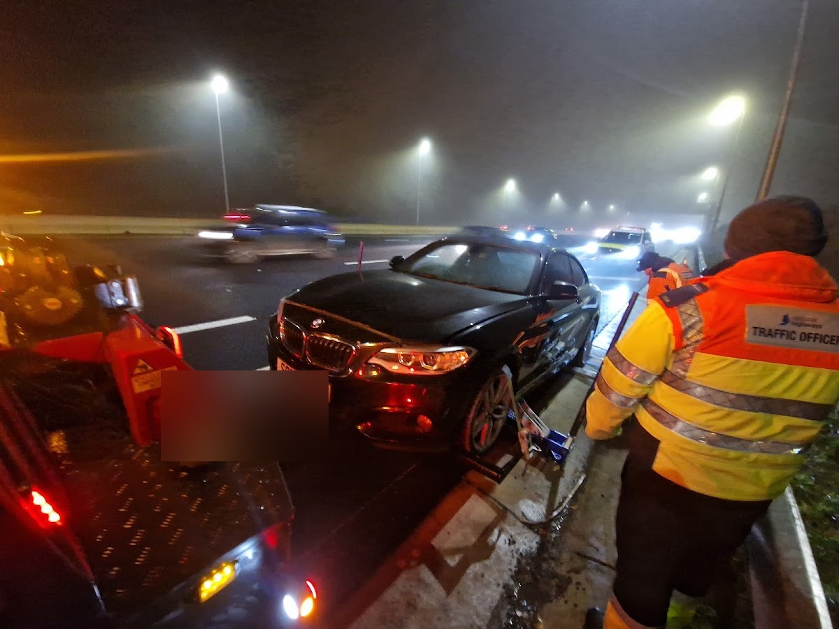 Motorway night BMW recovery with traffic officer.