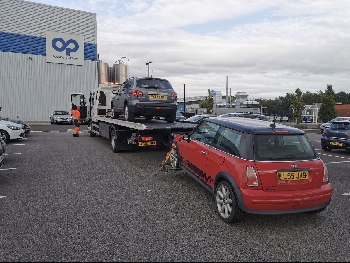 Silver Nissan Qashqai VK59 NAU loaded on the Breakdown Man recovery truck AY20 TWU towing a red Mini Cooper L55 JKB outside the Plastic Omnium plant