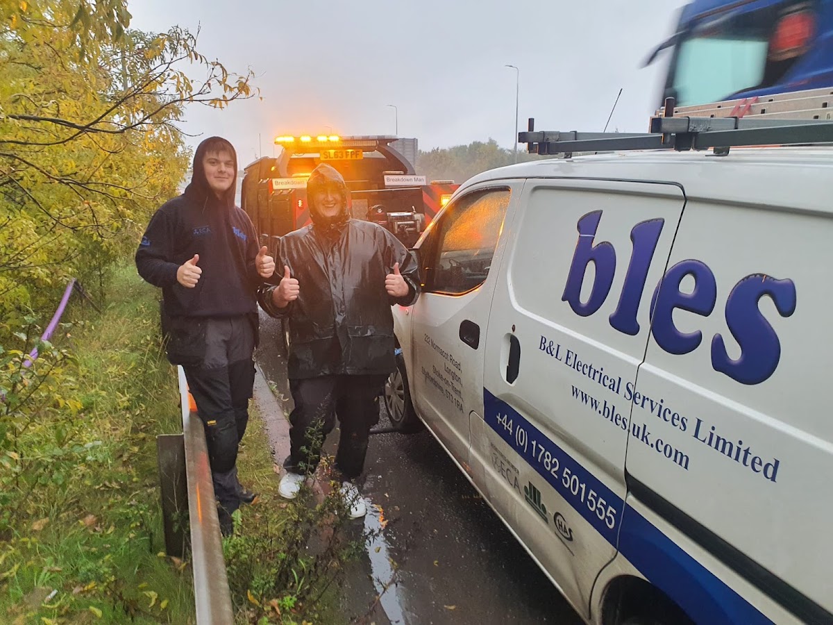 Simon and his son giving thumbs up on the motorway in the rain — real breakdown recovery team.