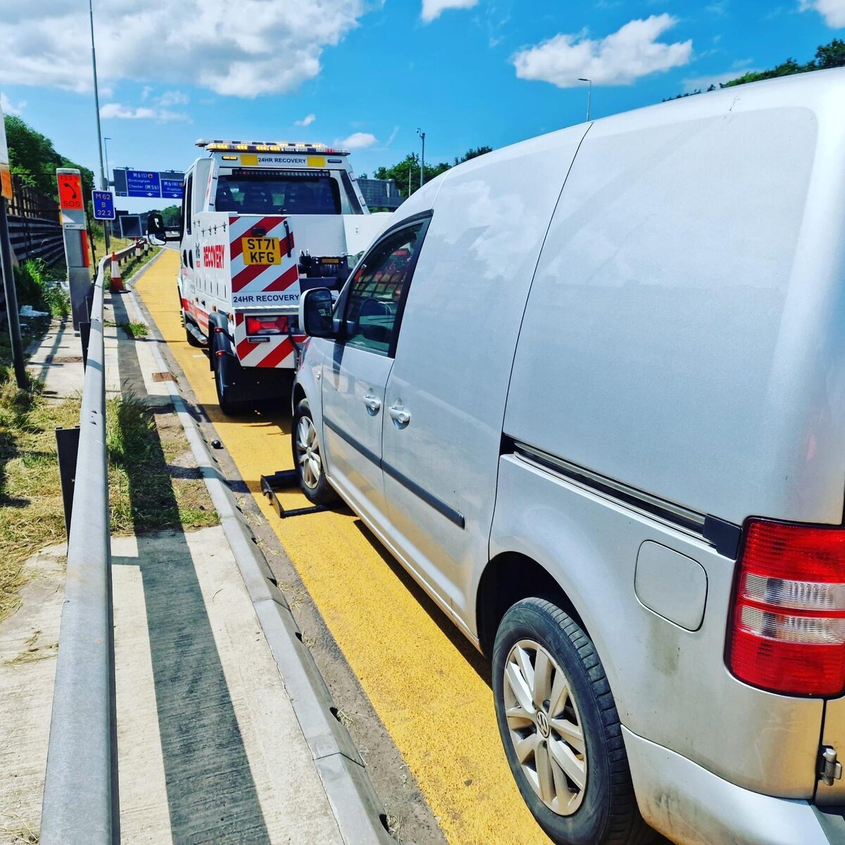 Silver Volkswagen Caddy van loaded behind Breakdown Man's recovery truck (ST71 KFG) on the motorway.