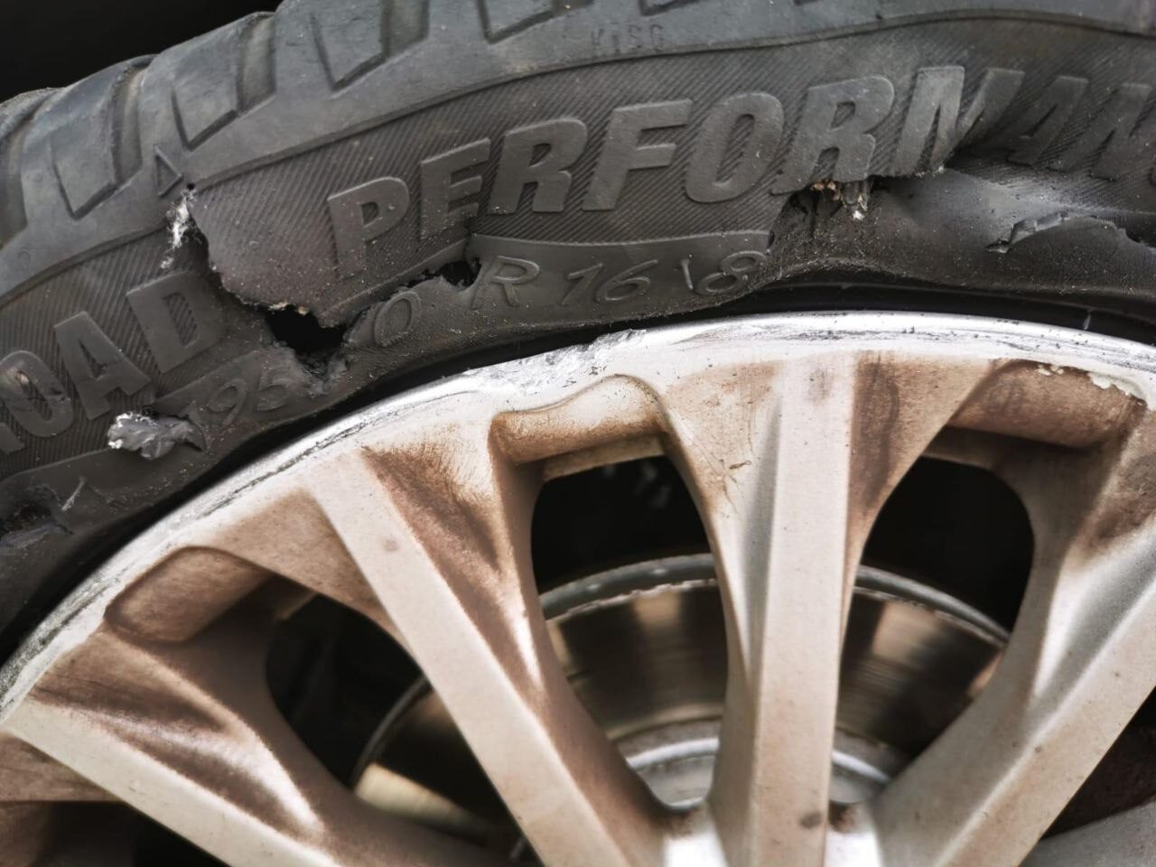 A car tyre with a torn, blown-out sidewall — damage like this means a replacement, not a repair.