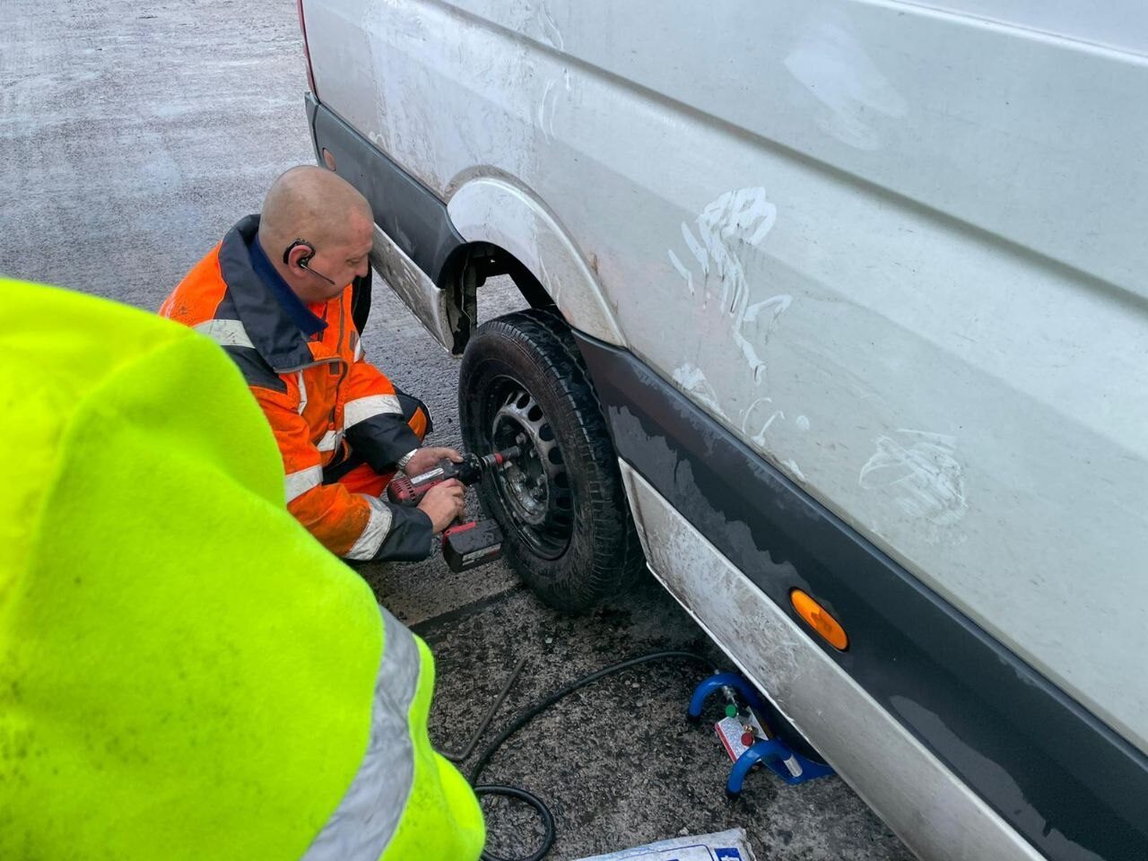 Simon using an impact wrench to change a van wheel at the roadside.