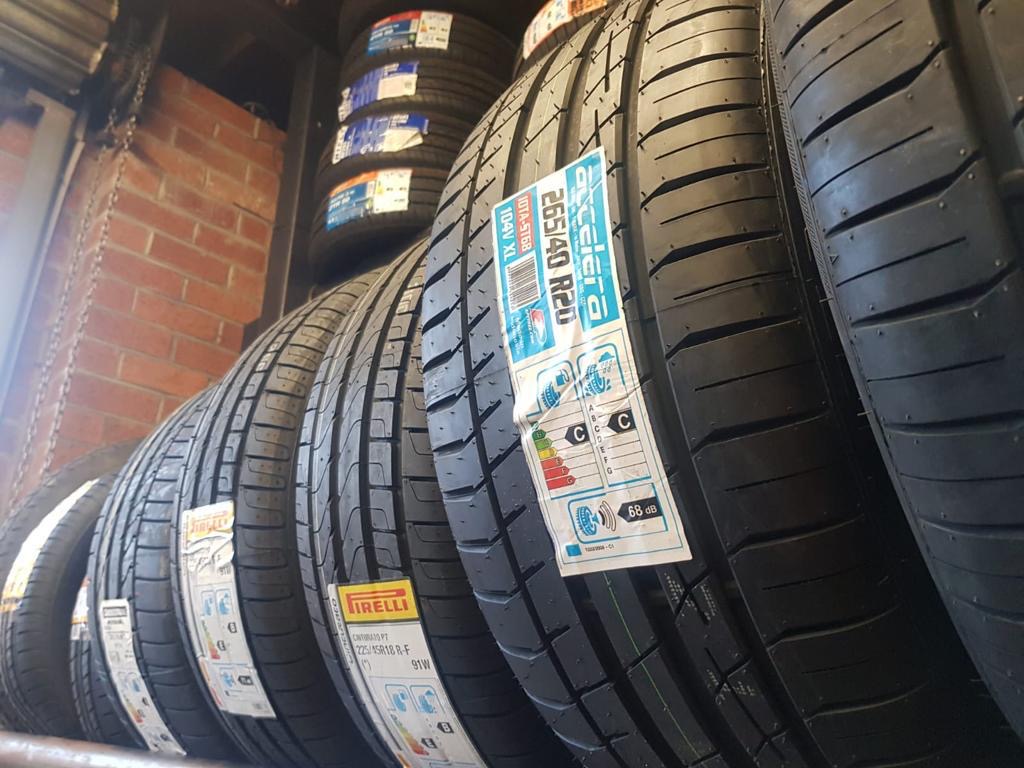 Mixed-brand tyres on a workshop rack.